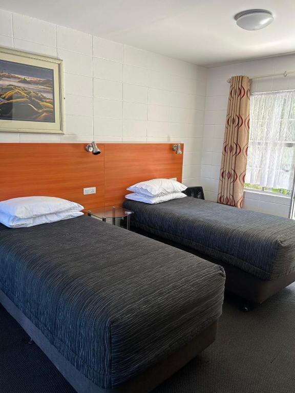Postel nebo postele na pokoji v ubytování Tudor Motor Lodge