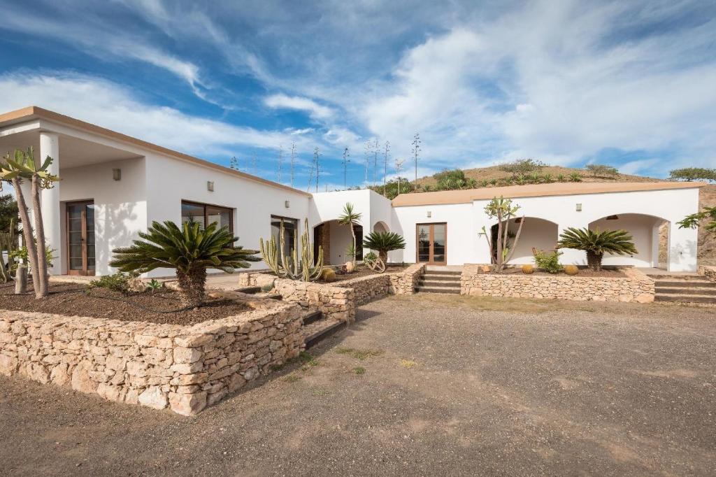 una casa con una pared de piedra delante de ella en Ferienhaus in Tuineje mit Großer Terrasse en Tesejerague