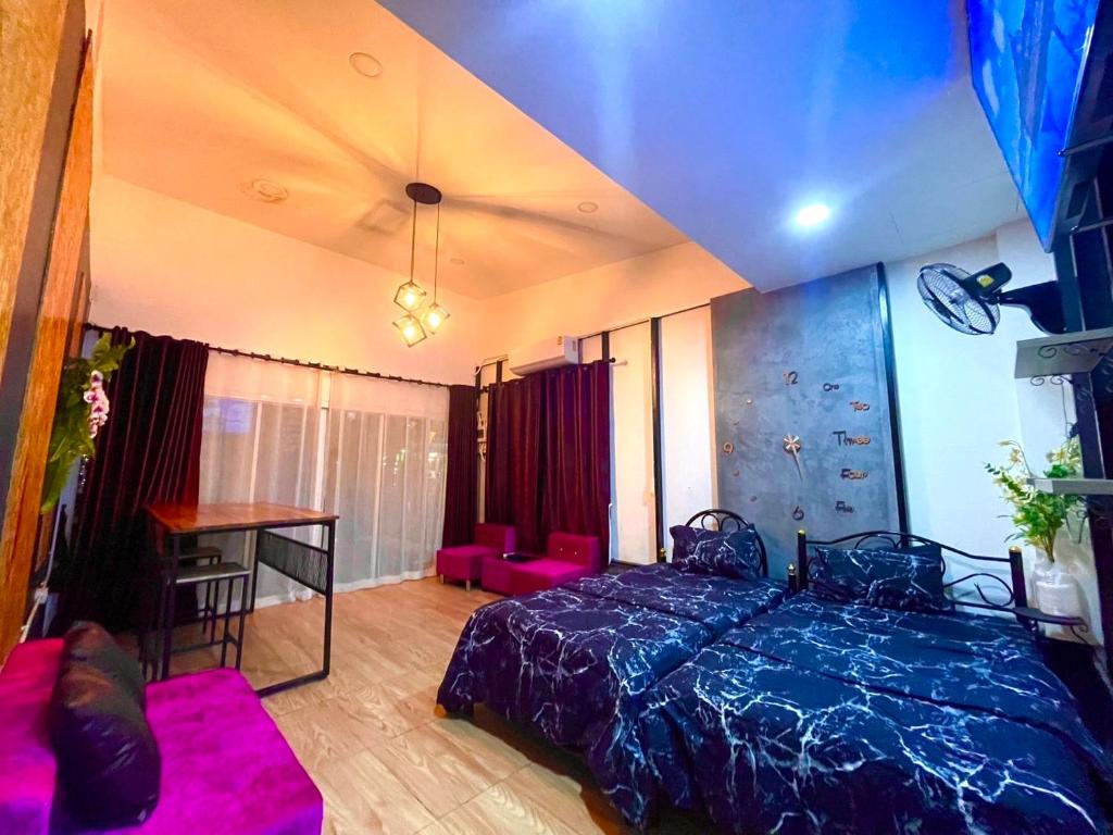 een slaapkamer met een bed, een tafel en een bureau bij Lamai Home in Ko Yao Noi
