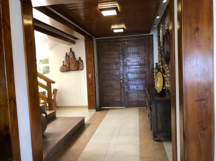 um corredor com uma grande porta de madeira e uma escada em Villa Santiago , La Loma de Ranchito Pichey em Santiago de los Caballeros