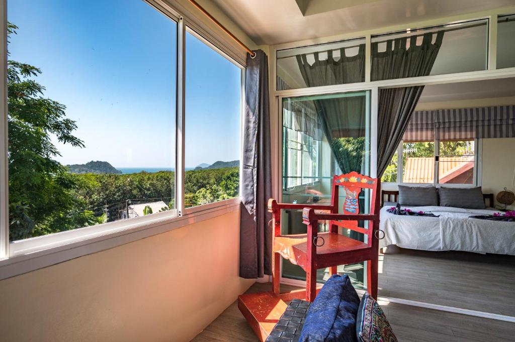 a room with a large window with a bed and a chair at Koh Mak Penthouse in Ko Mak