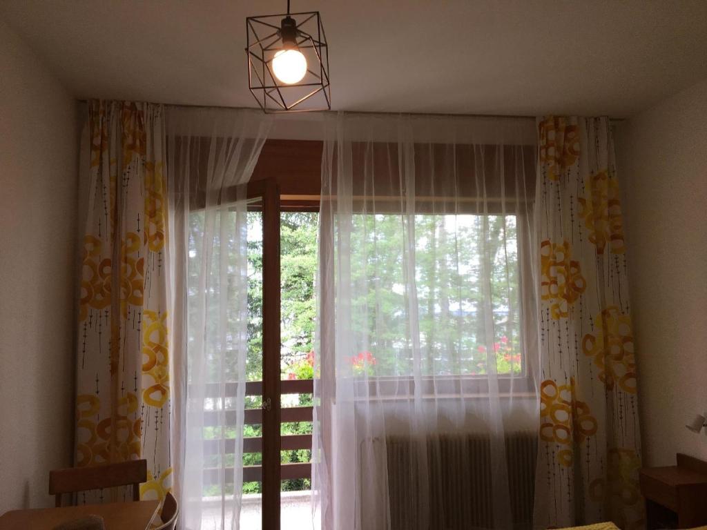 a room with a window with curtains and a light fixture at gemütliches neu renoviertes Gästezimmer mit Balkon - b58485 