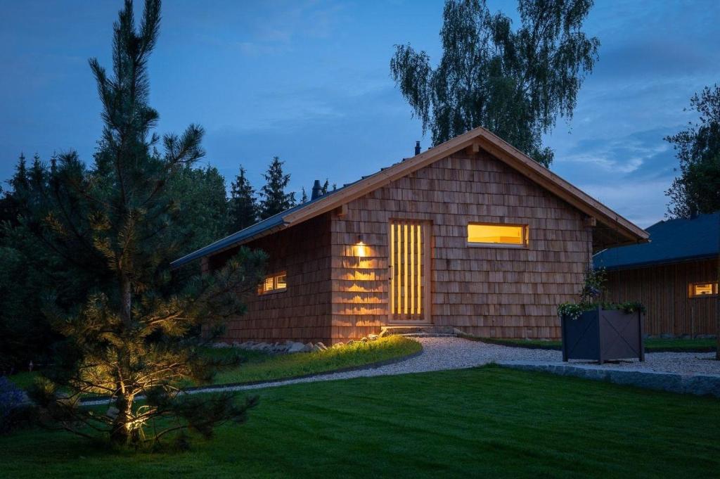 a small wooden house with a lit up window at FORSTGUT - Raum für wertvolle Zeit in Regen