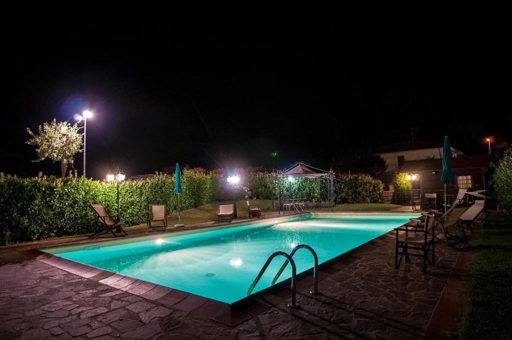 una piscina notturna con sedie e luci di Ferienhaus mit Privatpool für 6 Personen ca 120 qm in Lonnano, Toskana Provinz Arezzo a Pratovecchio