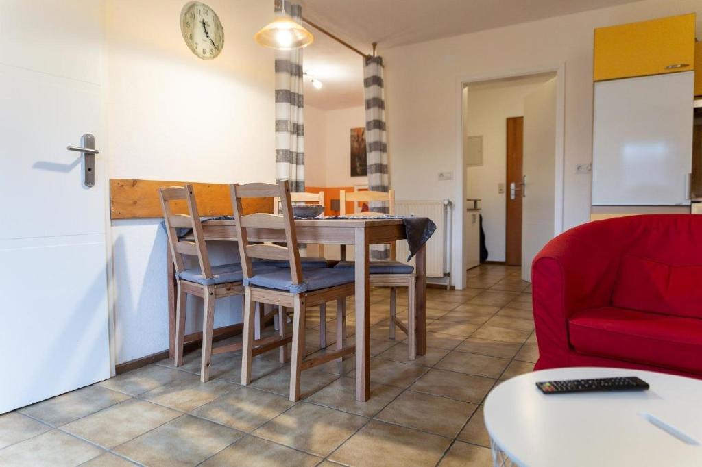 a kitchen and dining room with a table and chairs at Ferienwohnung mit Balkon, zwei Schlafzimmern und Küche mit Geschirrspülmaschine in Weißenstadt