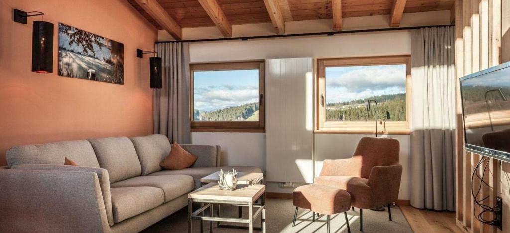 a living room with a couch and two windows at Unterkunft EXCLUSIVE FERIENWOHNUNG MIT EIGENER SAUNA in Regen