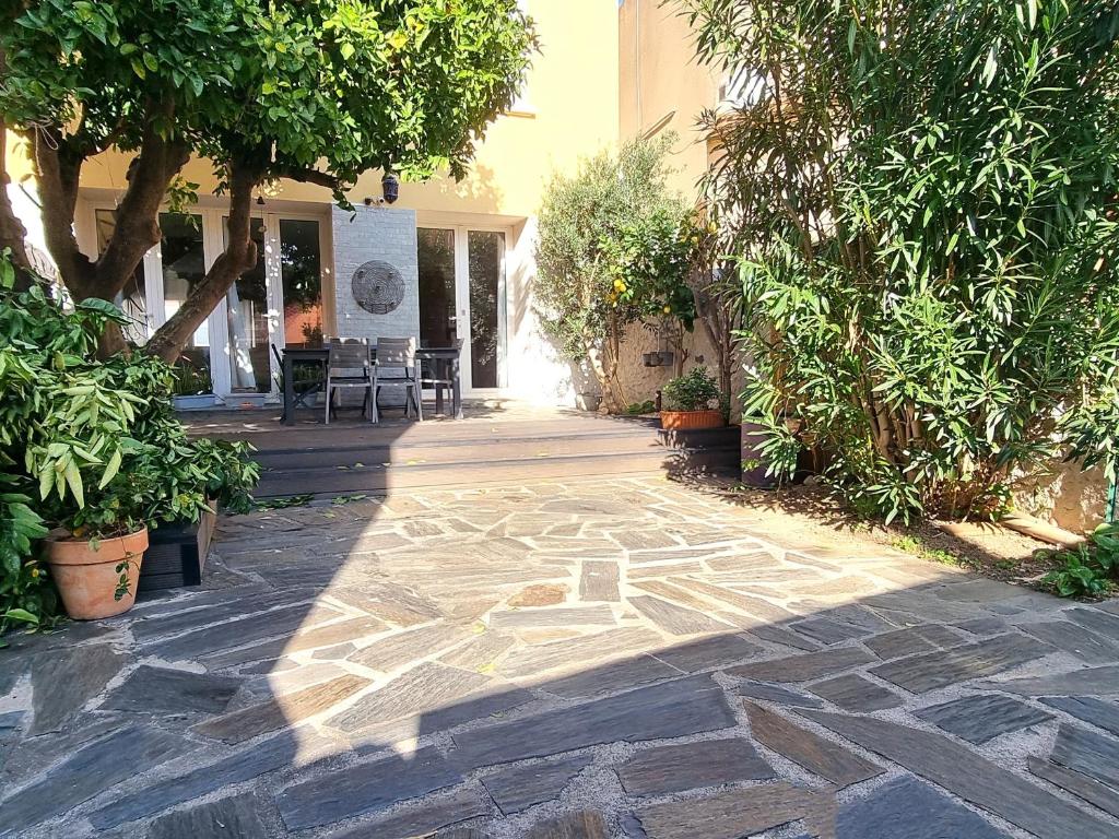 une terrasse avec une passerelle en pierre ornée d'arbres et de plantes dans l'établissement Maison à Banyuls-sur-Mer, climatisée, proche plage et commerces, jardin, 3 chambres - FR-1-309-437, à Banyuls-sur-Mer