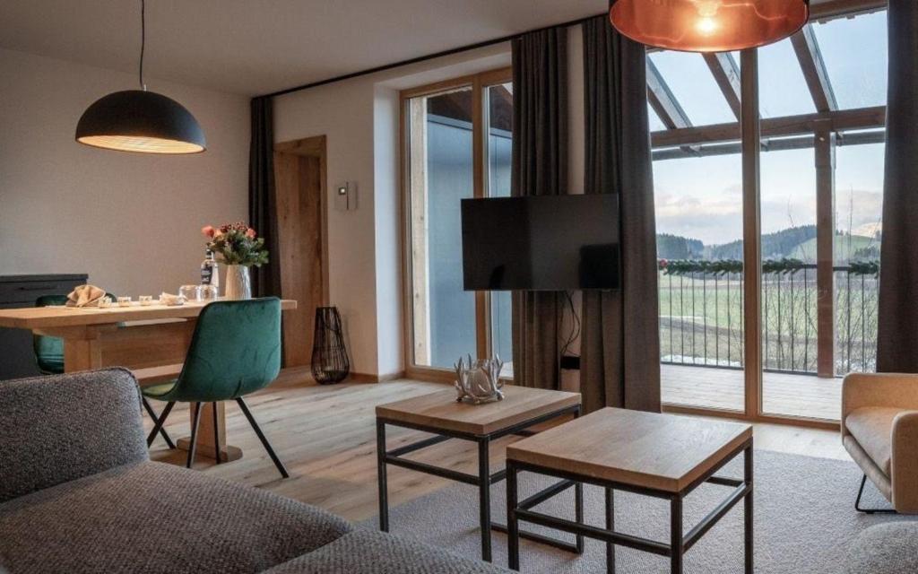 a living room with a couch and a table and a television at Unterkunft EXKLUSIVE FERIENWOHNUNG MIT EIGENER SAUNA in Regen