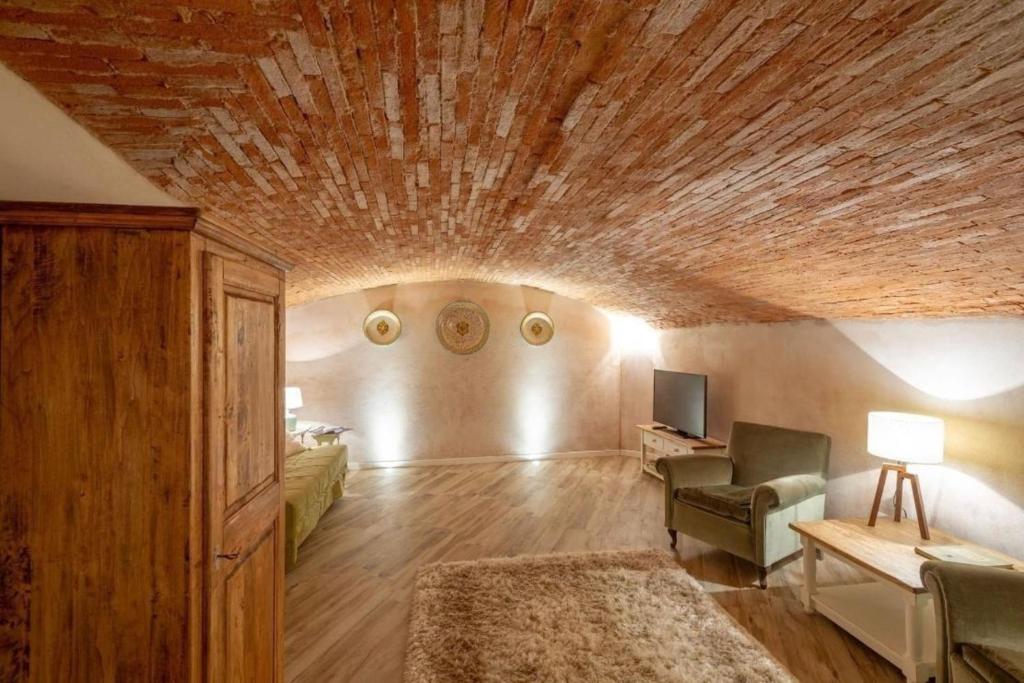 uma ampla sala de estar com tecto em madeira em Ferienwohnung Le Volte in der Residenza dei Piaceri Perduti em Lastra a Signa