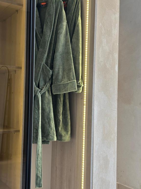 a green robe is hanging in a closet at شاليهات جزلا in Al Hofuf