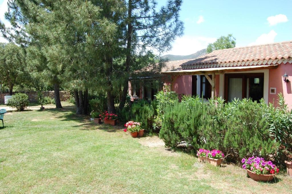 une maison avec une cour ornée de fleurs et de plantes dans l'établissement Gästezimmer für 2 Personen 1 Kind ca 30 qm in Loiri Porto San Paolo, Sardinien Gallura - b58194, à Biacci