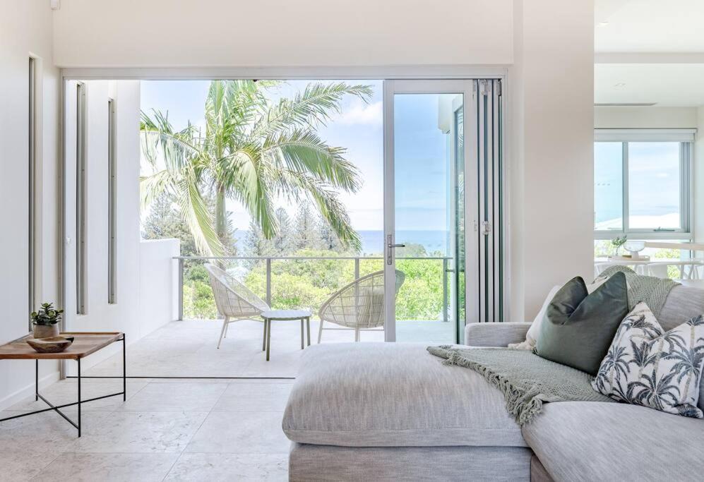 a living room with a couch and a view of the ocean at The Platinum Luxury Villa ~ Walk to Beach, Village in Sunshine Beach
