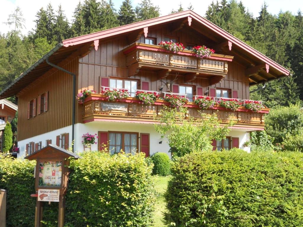 una casa con flores en sus balcones en Komfortable Ferienwohnung im zweiten Obergeschoss mit herrlichem Bergblick en Reit im Winkl