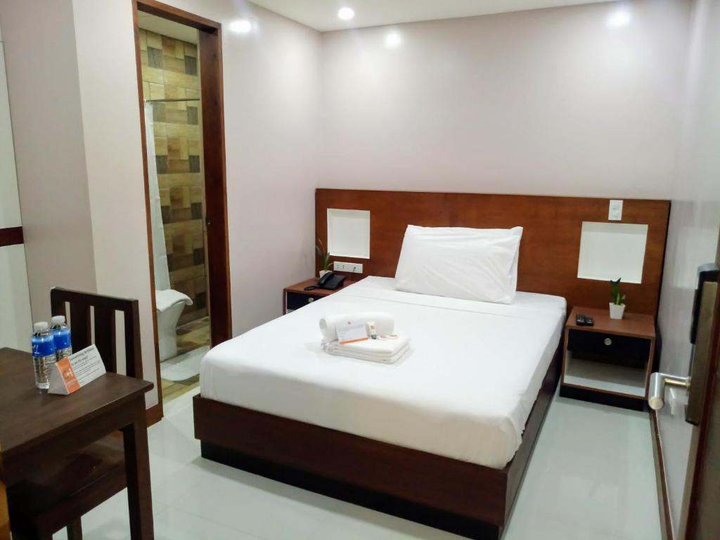 1 dormitorio con cama, mesa y espejo en coastal hotel, en Iloilo City