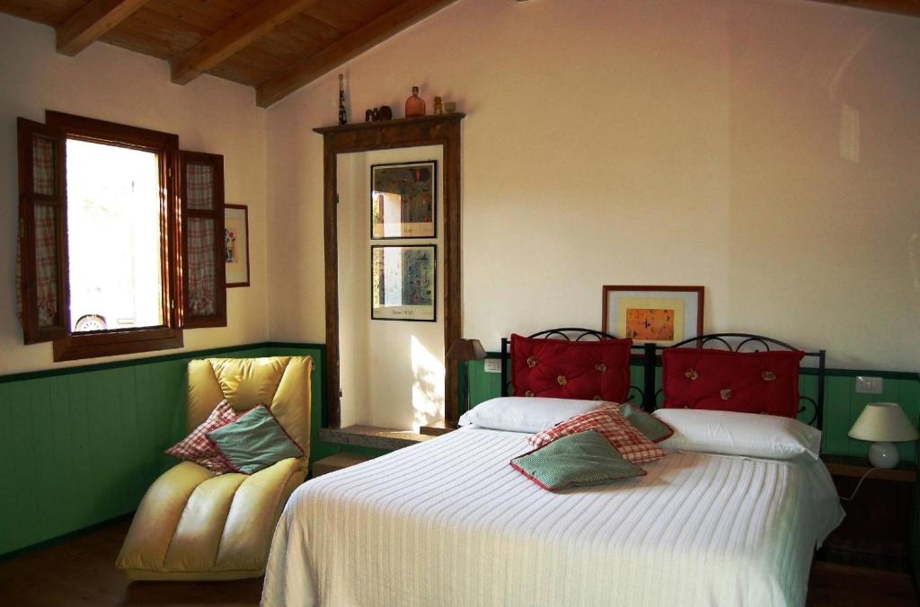 una camera con un grande letto e due sedie di Gästezimmer für 2 Personen 1 Kind ca 30 qm in Loiri Porto San Paolo, Sardinien Gallura - b58193 a Biacci