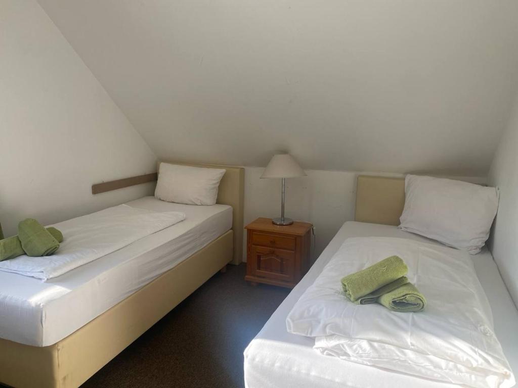 two twin beds in a room with a night stand at Room in Guest room - Pension Forelle - double room 001 in Forbach