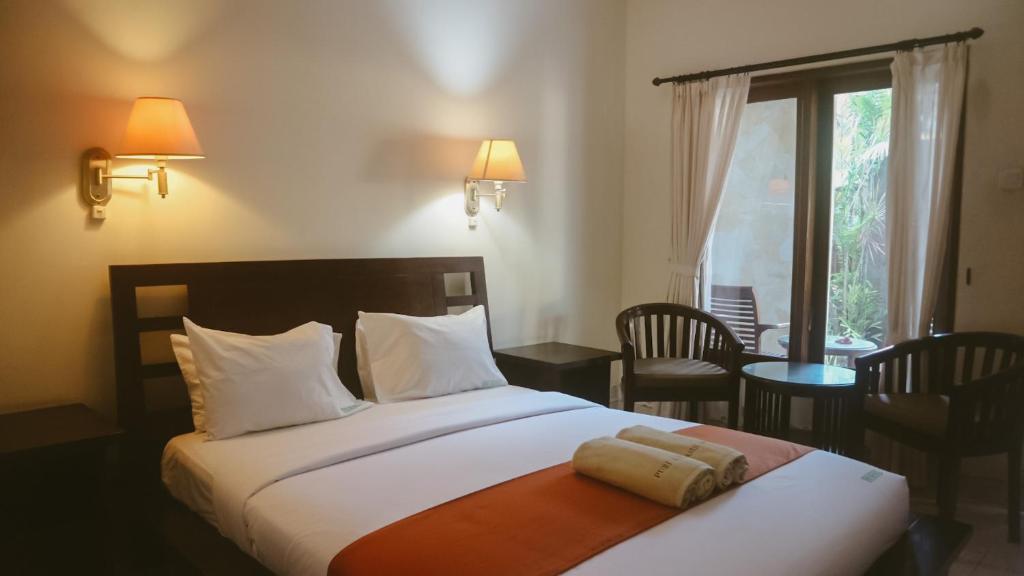 Kama o mga kama sa kuwarto sa New Puri Asih Hotel