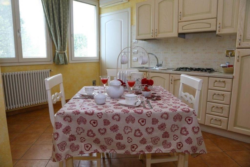 een keuken met een tafel met een rode en witte tafeldoek bij Lavanda - Studio-Apartment auf einem Bauernhof im Grünen zwischen Reggio und Modena in Scandiano