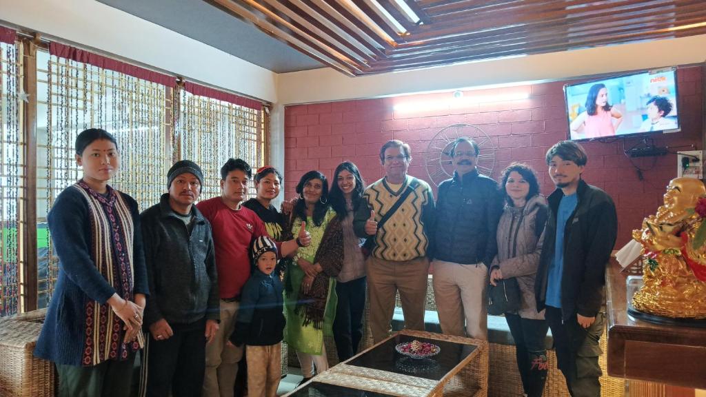 un grupo de personas posando para una foto en una habitación en Hotel Deysal Noora en Bomdila