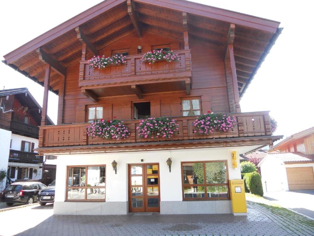 a building with a balcony with flowers on it at Gemütliche Ferienwohnung mit Balkonen, direkt im Ortszentrum von Reit im Winkl in Reit im Winkl