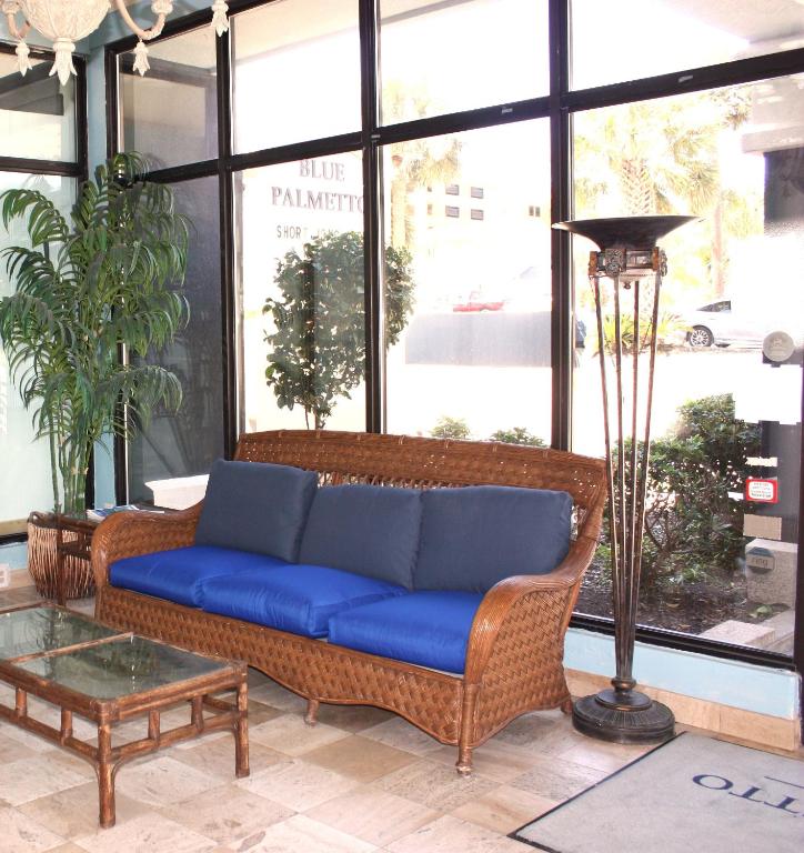a blue couch in a room with a large window at Blue Palmetto Vacation Rentals in Myrtle Beach