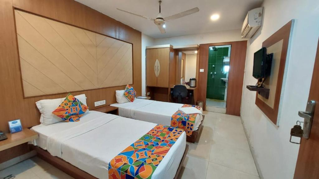 a hotel room with two beds and a flat screen tv at Hotel Park Resort Bhubaneswar Couple Friendly in Bhubaneshwar