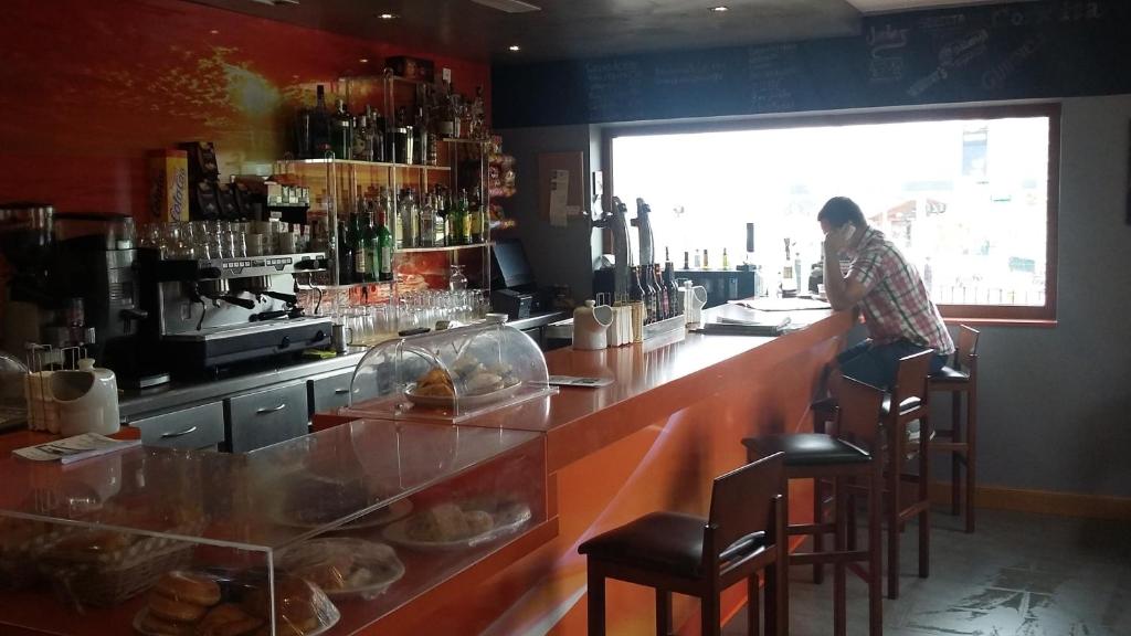 una persona sentada en un bar en un restaurante en Hotel Valle de Cabezón, en Cabezón de la Sal