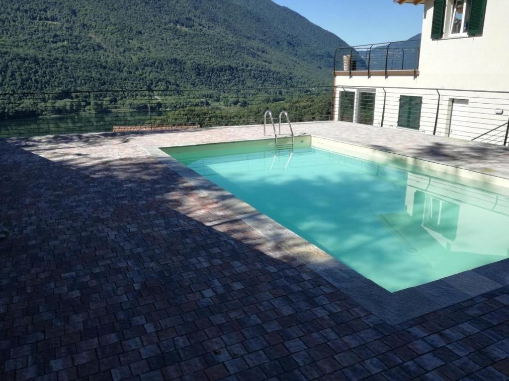 uma piscina em frente a uma casa em Komfortable Wohnung in Carlazzo mit Privatem Garten em Carlazzo
