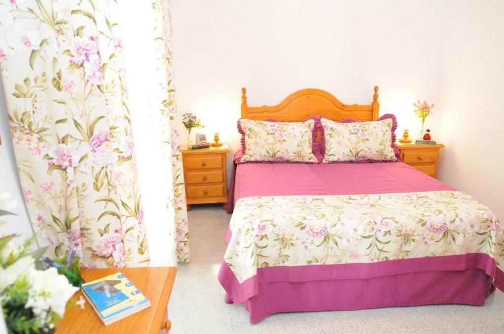 ein Schlafzimmer mit einem Bett mit einer rosa Tagesdecke und einem Tisch in der Unterkunft Studio für 5 Personen  1 Kind ca 74 qm in Vecindario, Gran Canaria Ostküste Gran Canaria in Vecindario