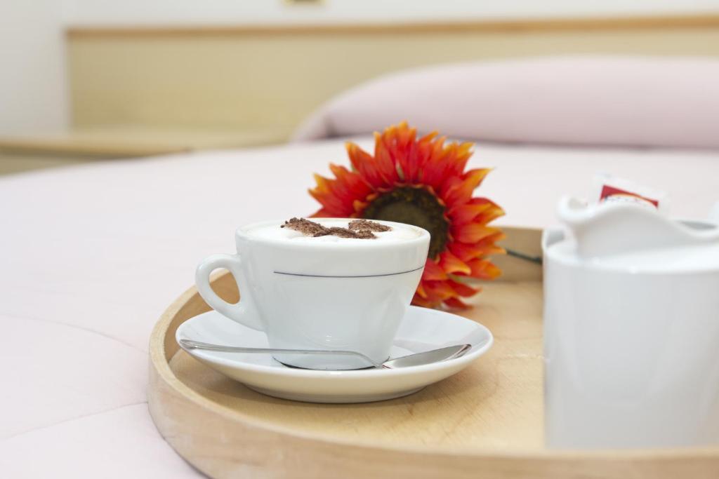 una tazza di caffè su un tavolo con un fiore di Il Grifo Hotel e Bisteccheria Toscana a Montepulciano