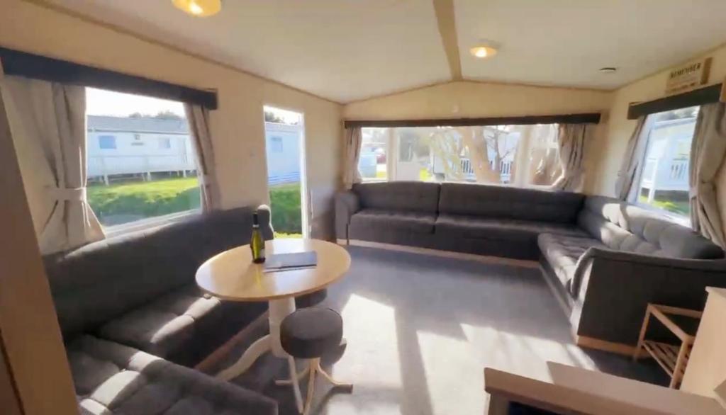 a living room with a couch and a table at Cosy holiday home stay in Great Clacton
