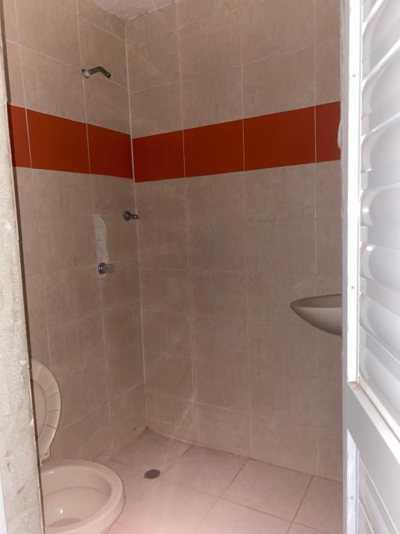 een badkamer met een douche, een toilet en een wastafel bij Festivalvallenatohabitaion in Valledupar