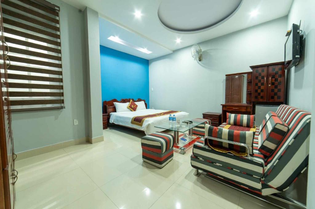 a living room with a bed and a table and chairs at Stargazerhotel Đà Nẵng- Khách sạn Hoa Ly in Da Nang