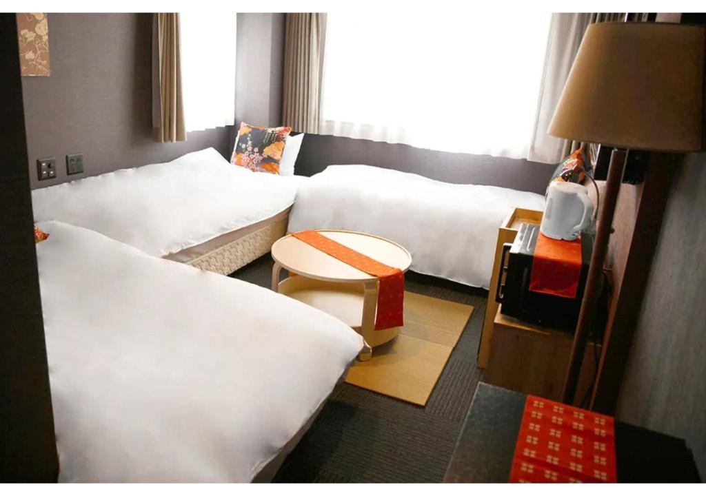 Postel nebo postele na pokoji v ubytování HOTEL LEGASTA KYOTO SHIRAKAWA SANJO