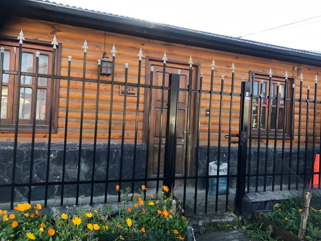 una cerca frente a una casa de madera con flores en Las Caléndulas en Ushuaia