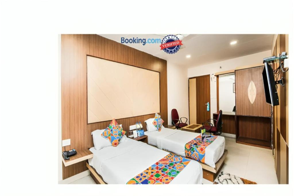 una camera d'albergo con due letti e un grande schermo di Hotel Park Resort Bhubaneswar Couple Friendly a Bhubaneshwar