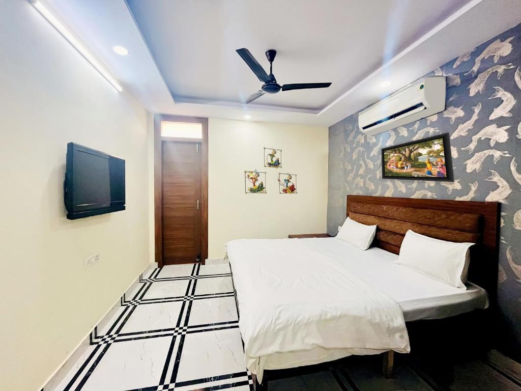 a bedroom with a bed and a flat screen tv at Roomshala 168 Starlight Suites - Near Max Hospital in New Delhi