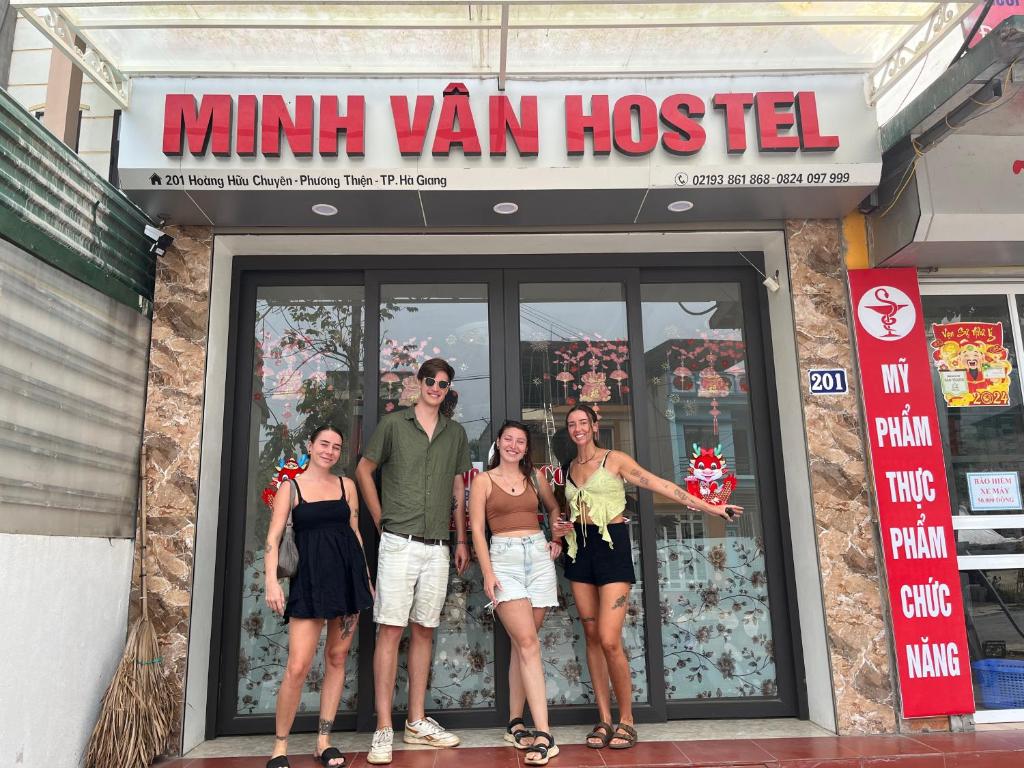 um grupo de pessoas em pé em frente a um mini-van hostel em Minh Vân Hostel em Ha Giang