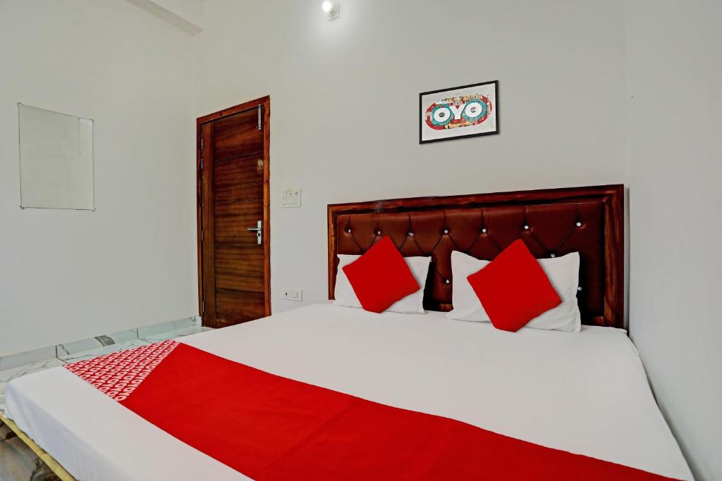 a bedroom with a large bed with red pillows at Flagship Rudra Banquet And Resorts in Morādābād