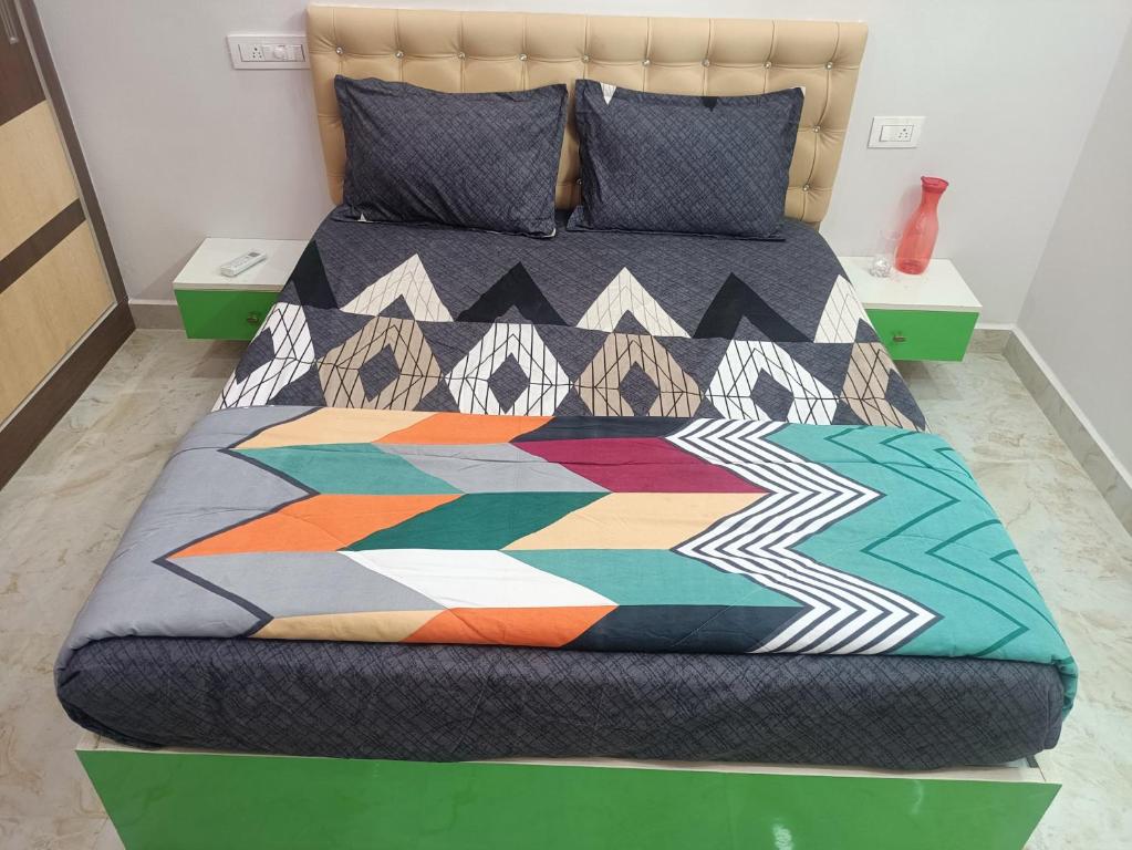 a bed with a colorful quilt on it in a room at RRRHomestay in Tirupati
