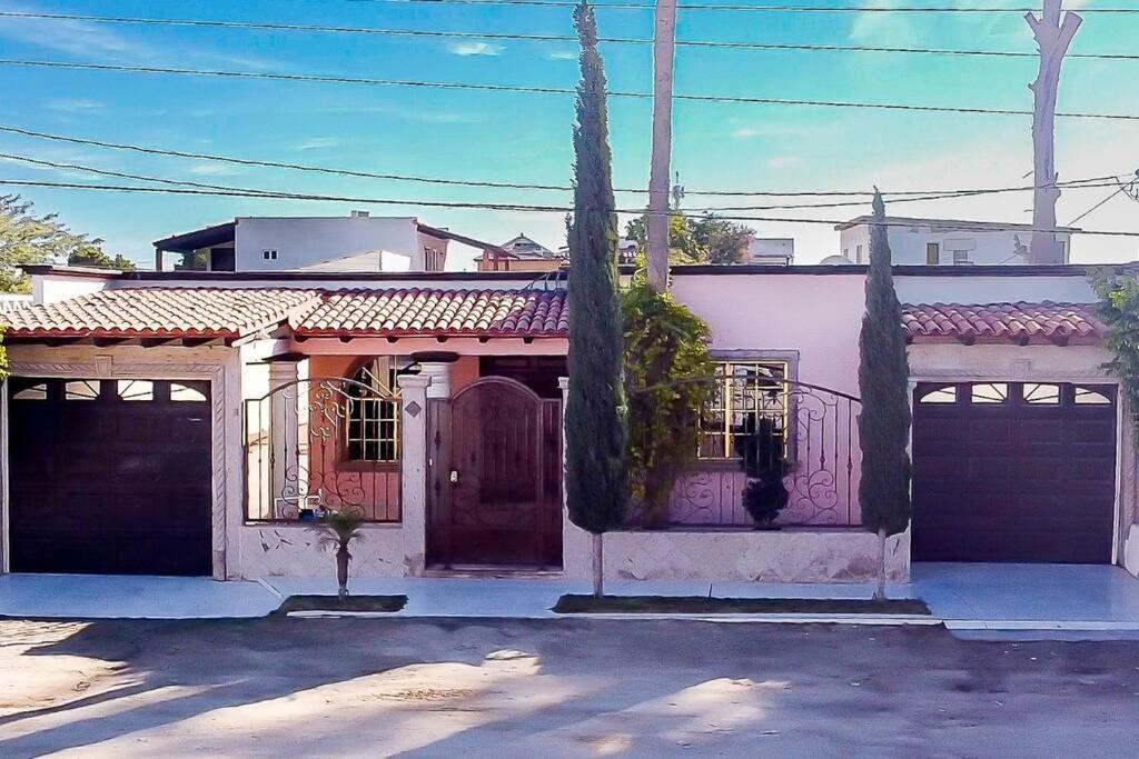 una casa blanca con una puerta y un garaje en ROCKY POINT DELPHINE HOME, COZY,POOL AFFORDABLE., en Puerto Peñasco