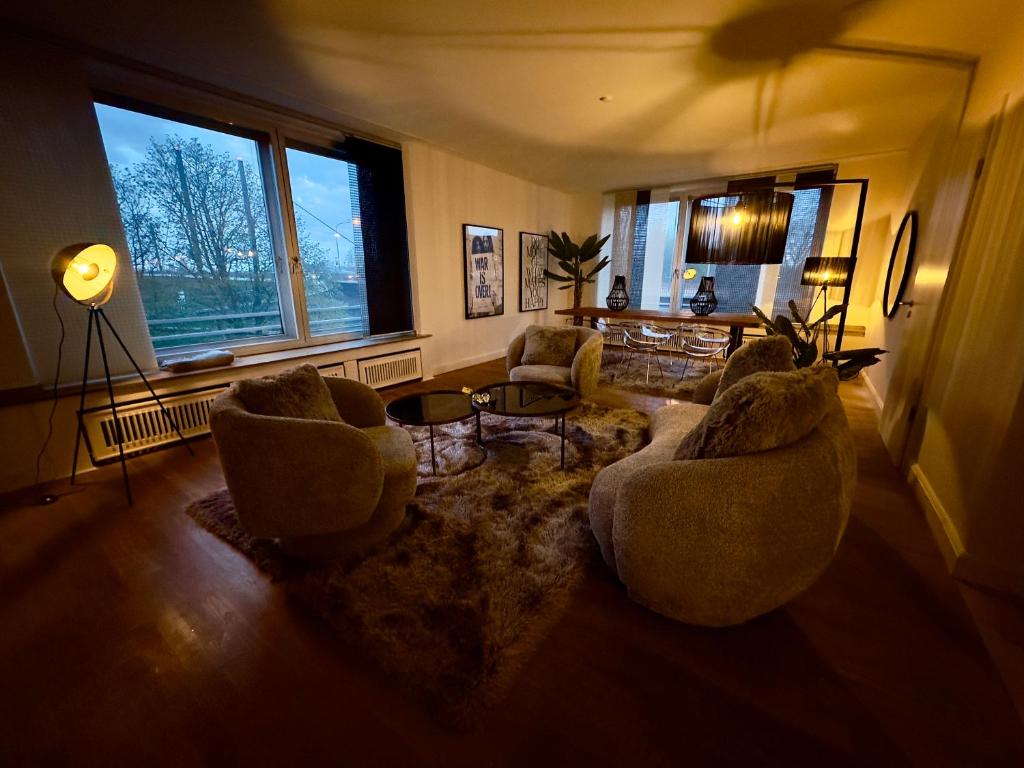 ein Wohnzimmer mit 2 Stühlen und einem Sofa in der Unterkunft Atemberaubender Rheinblick Messe in Düsseldorf