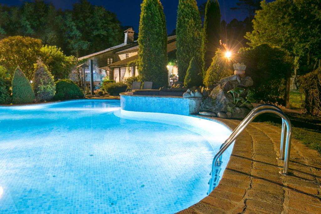 una piscina en un patio por la noche en Aldea Os Muiños, en As Mirans