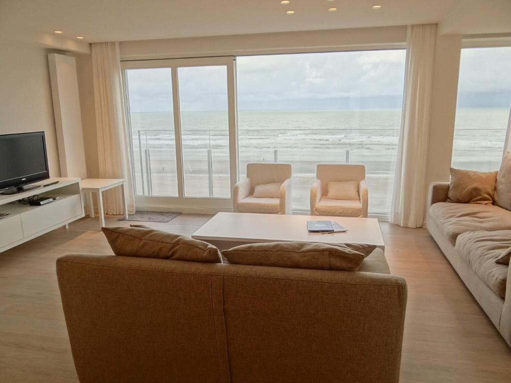 sala de estar con sofá y ventana grande en Horizon 0501 located on the sea wall, en Nieuwpoort