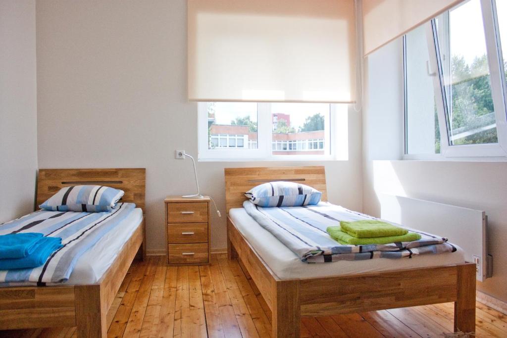 two twin beds in a room with two windows at Viru Maja in Tallinn