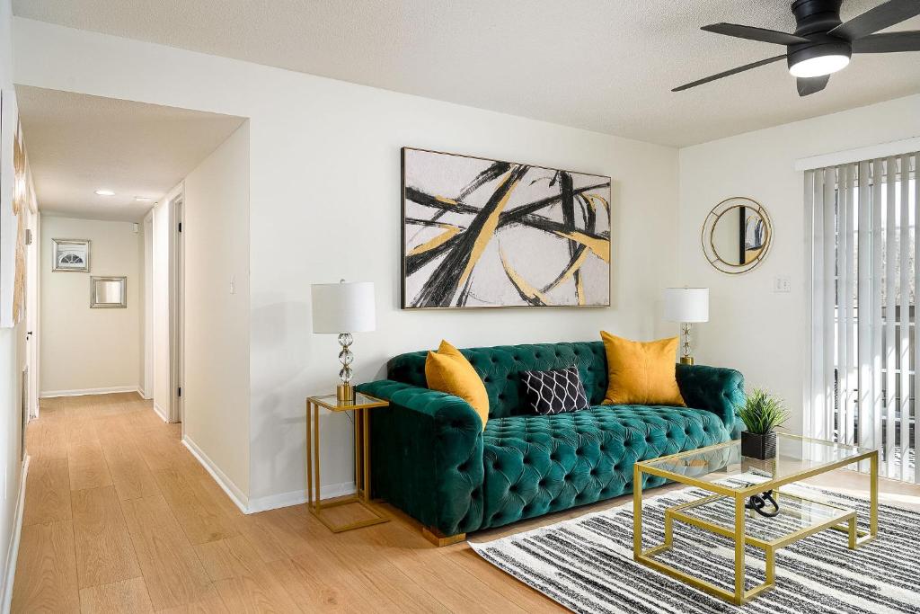 a living room with a green couch at Emerald Retreat - Central & Stylish - 2 BR/2 BA in Winston-Salem