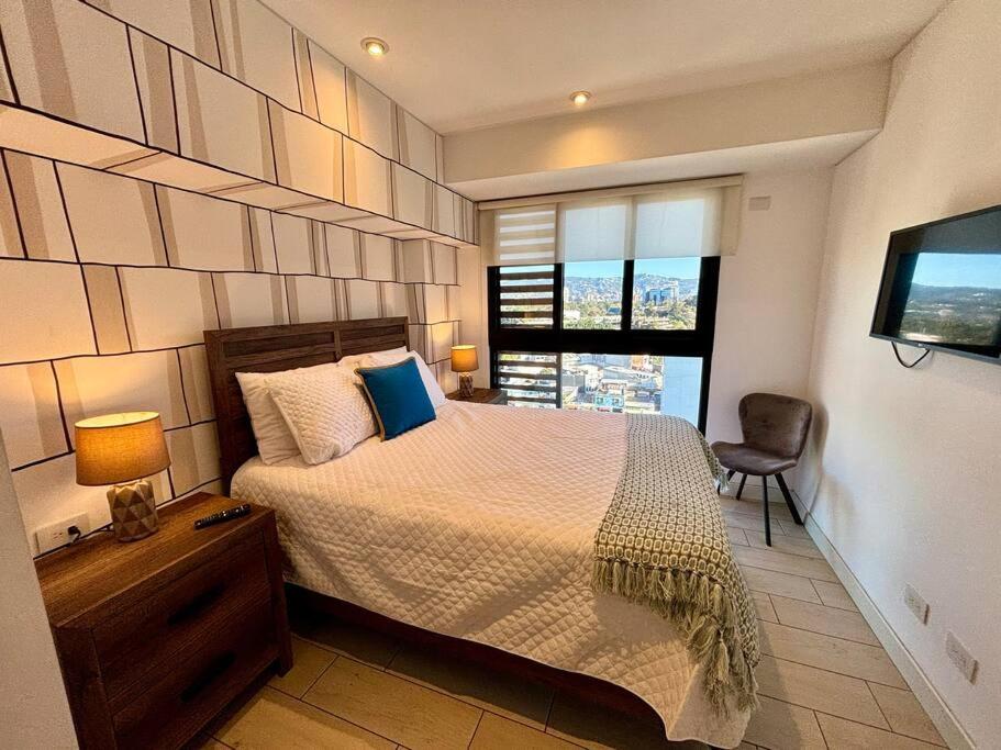 a bedroom with a large bed and a window at Guatemala Gem in zone 4 in Guatemala