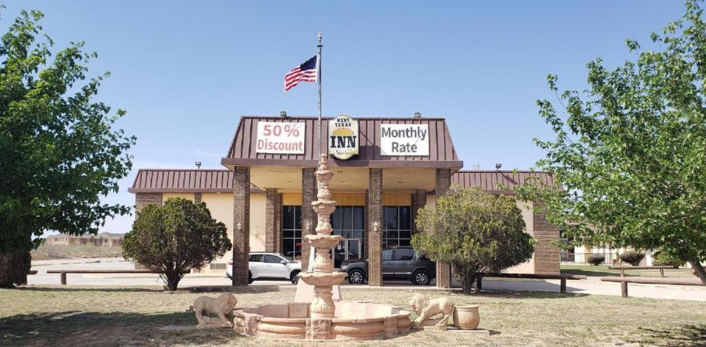 een gebouw met een Amerikaanse vlag erop bij West Texas Inn & Suites Midland in Midland