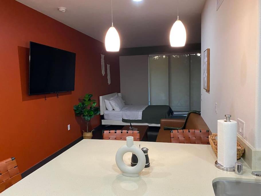 ein Wohnzimmer mit einem Tisch und einem TV an der Wand in der Unterkunft Chic and Modern unit in Los Angeles