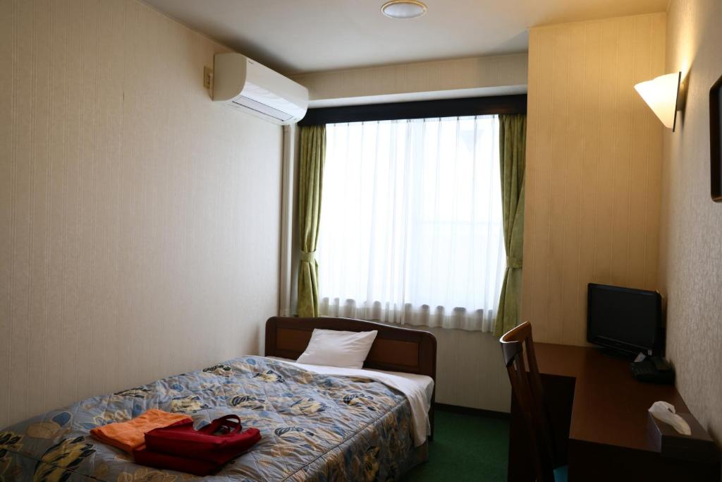 Postel nebo postele na pokoji v ubytování 八尾グランドホテル